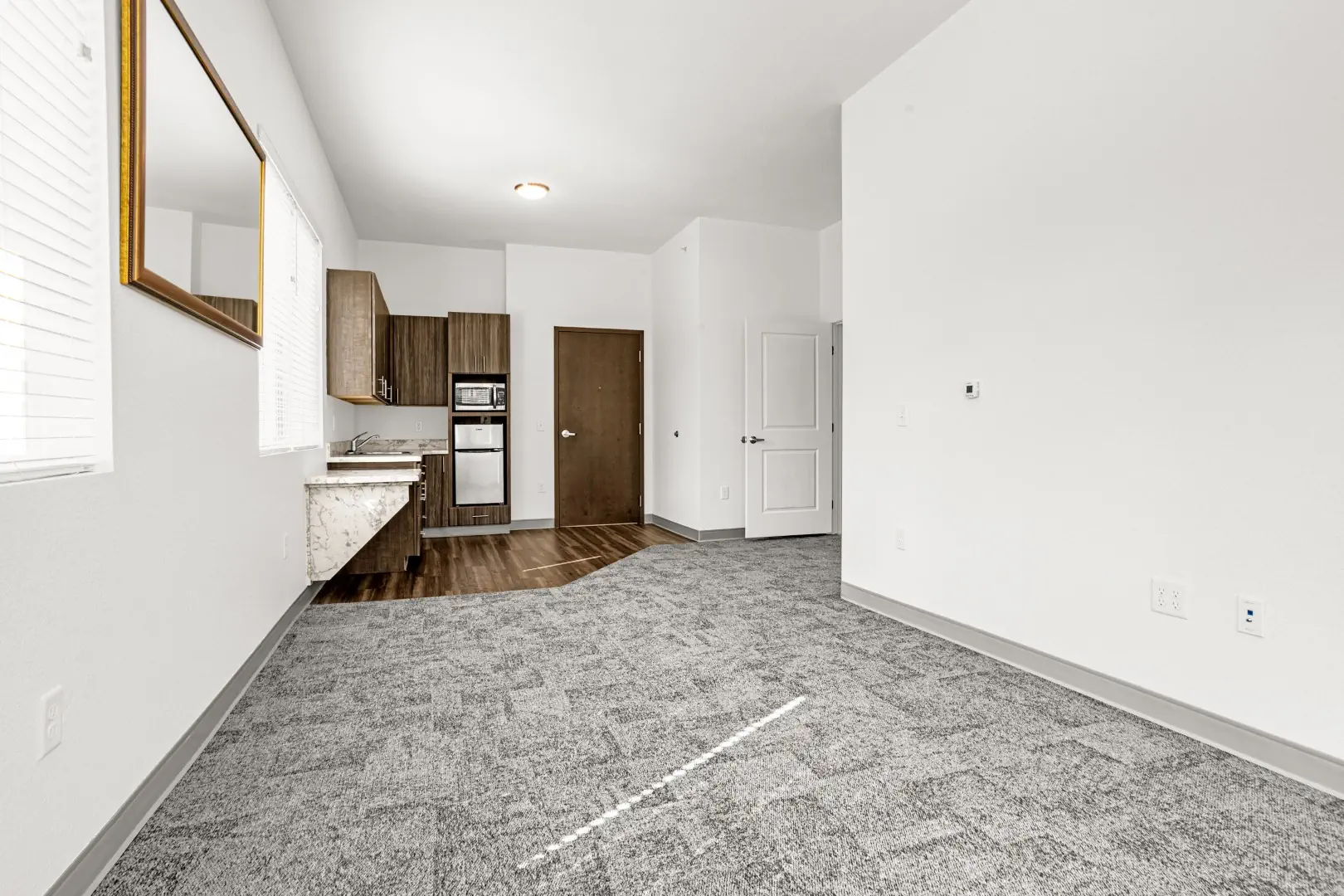 Standing in corner of one bedroom apartment looking towards door.