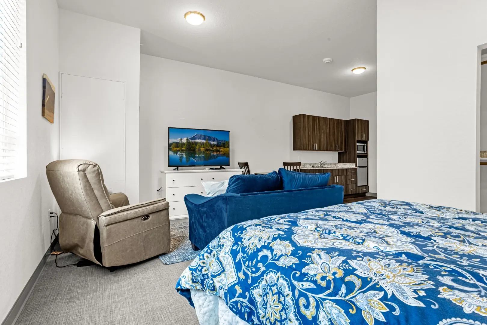 Looking from bedroom area to living area in studio apartment at Greeley Village Assisted Living.